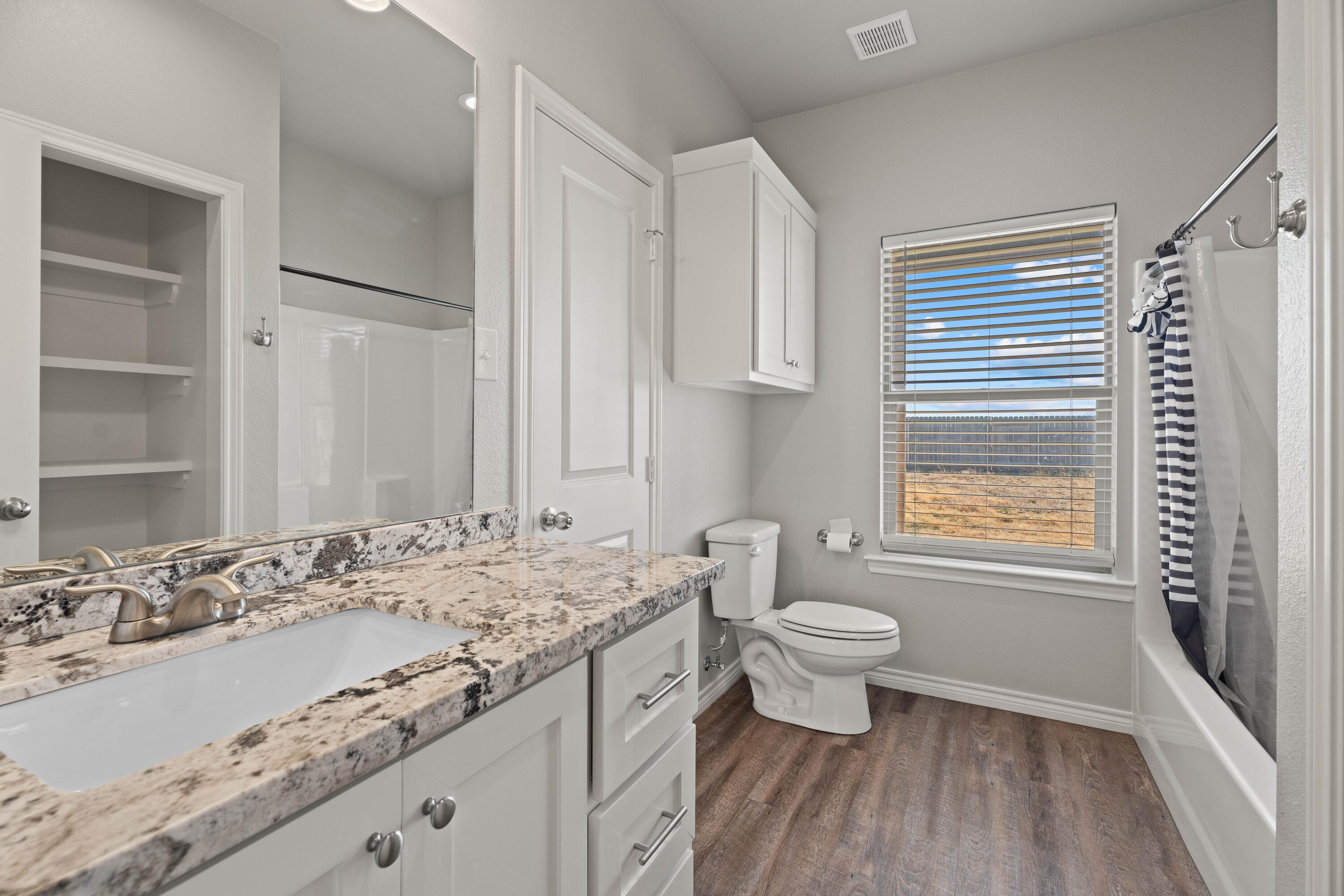 8907 County Road 6100 Shallowater, TX 79363 - Photo 17 of 24 a bathroom with a granite countertop sink a toilet and a bathtub