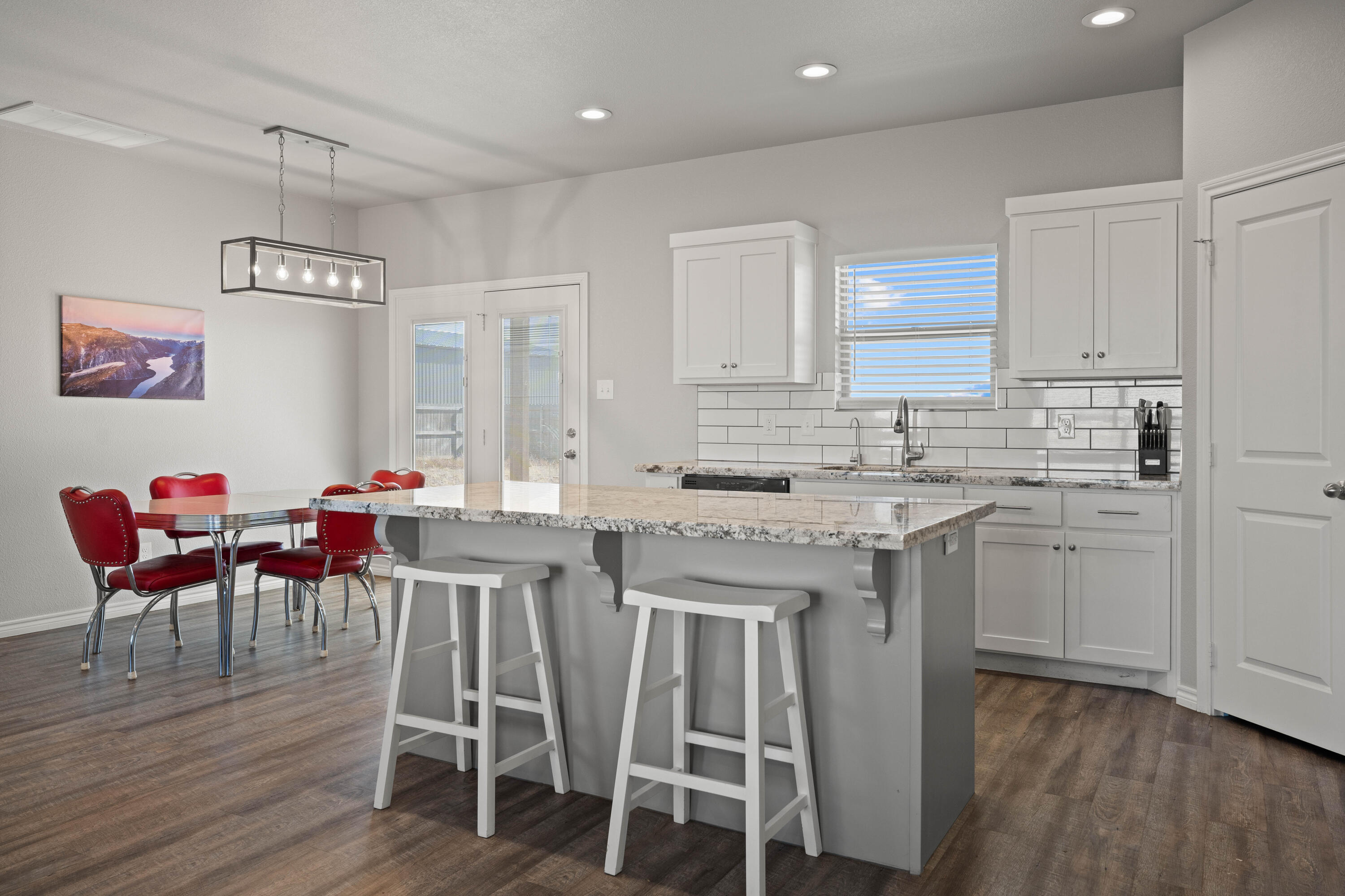 8907 County Road 6100 Shallowater, TX 79363 - Photo 10 of 24 a kitchen with stainless steel appliances granite countertop a table chairs sink and white cabinets