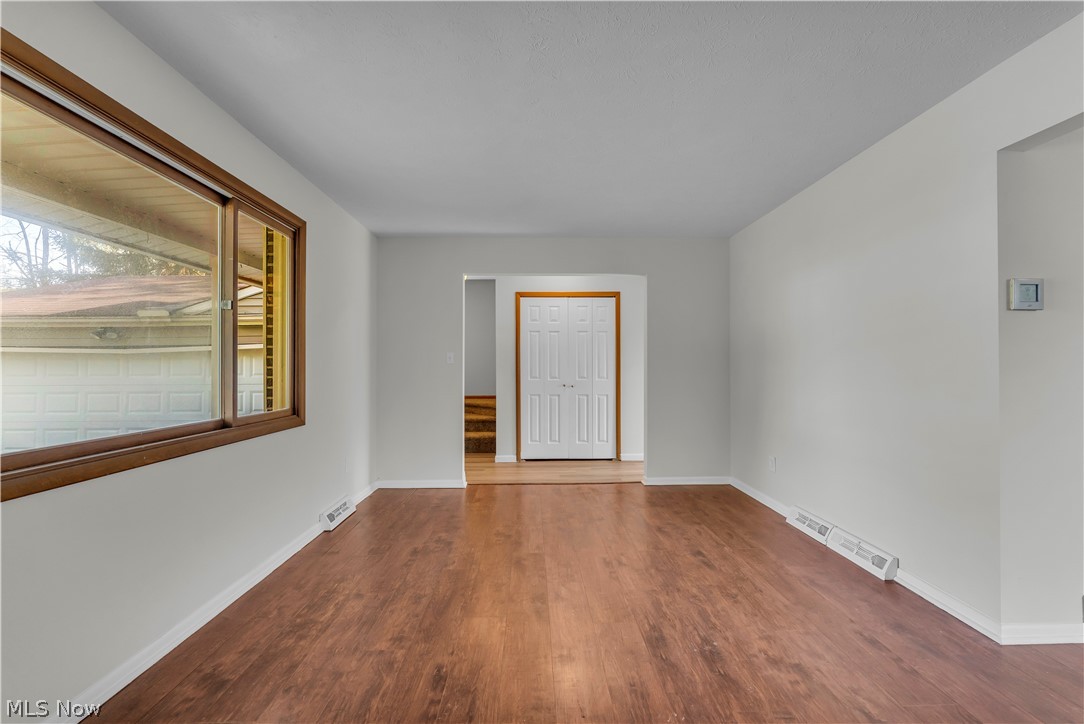 2540 Charney Road University Heights, OH 44118 - Photo 6 of 44 Spacious interior room featuring wood-finish flooring, white walls, and a large window with brown trim