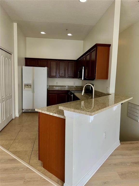 6404 South Goldenrod Road, Unit 2A Orlando, FL 32822 - Photo 11 of 40 a kitchen with stainless steel appliances a stove a microwave a sink and a refrigerator