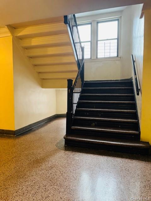 92-05 Whitney Avenue, Unit A27 Queens, NY 11373 - Photo 13 of 14 Stairs with speckle patterned floor and baseboards