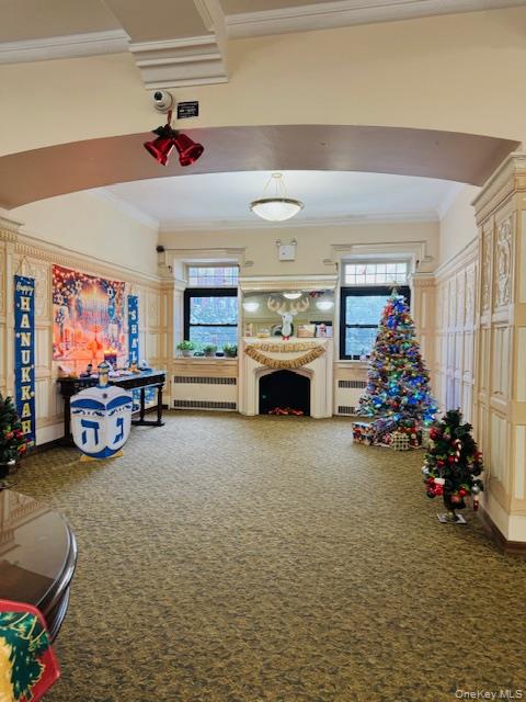 92-05 Whitney Avenue, Unit A27 Queens, NY 11373 - Photo 14 of 14 Rec room with ornamental molding, carpet, healthy amount of natural light, and radiator heating unit