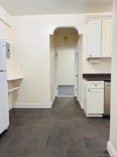 92-05 Whitney Avenue, Unit A27 Queens, NY 11373 - Photo 2 of 14 Kitchen featuring white cabinetry, dishwasher, freestanding refrigerator, and arched walkways
