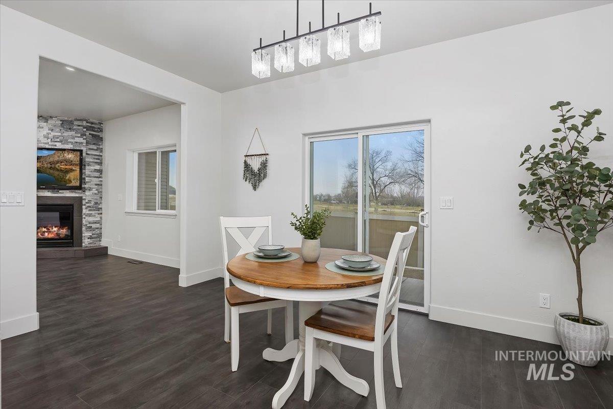 1189 Trail Crest Road Twin Falls, ID 83301 - Photo 16 of 44 Dining area featuring dark wood-type flooring and a large fireplace