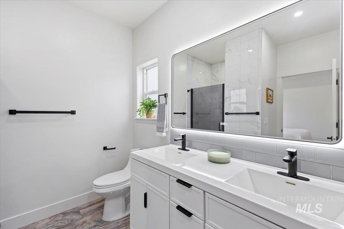 1189 Trail Crest Road Twin Falls, ID 83301 - Photo 21 of 44 Full bathroom featuring double vanity, a marble finish shower, ensuite bathroom, and dark wood-style floors