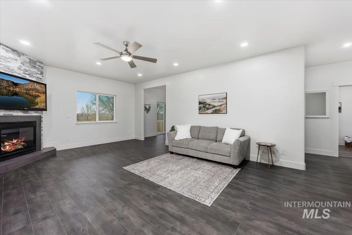 1189 Trail Crest Road Twin Falls, ID 83301 - Photo 6 of 44 Living room with a fireplace, a ceiling fan, dark wood-style floors, and recessed lighting
