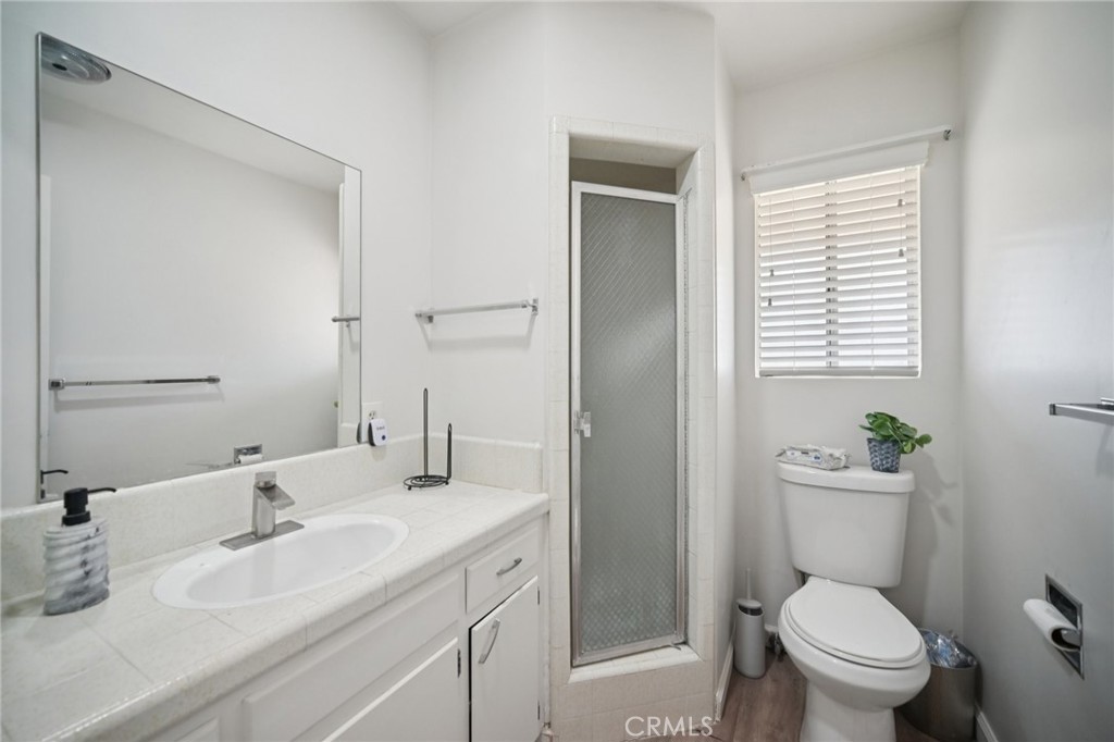 47078 Kings Canyon Road Lancaster, CA 93536 - Photo 19 of 63 a bathroom with a granite countertop toilet a sink and a mirror