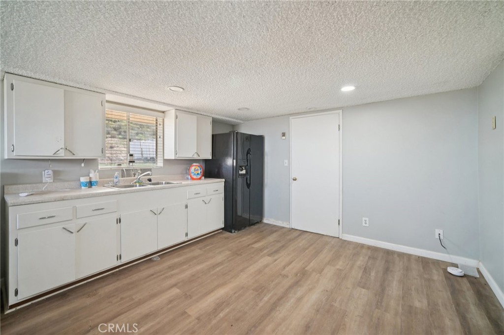 47078 Kings Canyon Road Lancaster, CA 93536 - Photo 30 of 63 a view of a kitchen with a sink cabinets and wooden floor
