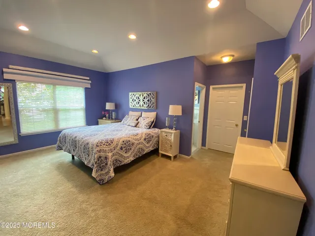 a bedroom with a bed and large windows