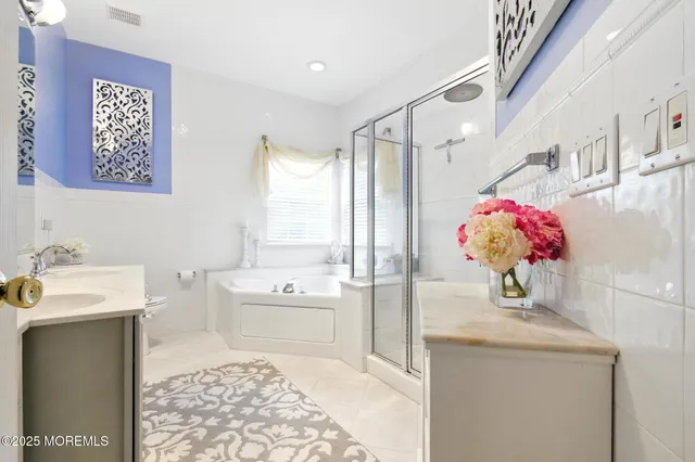 a bath room with a sink vanity tub and a view of bathroom
