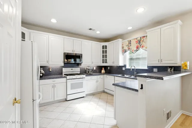 a kitchen with white cabinets sink and stainless steel appliances