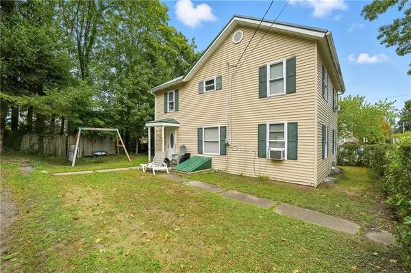 a view of backyard of house with wooden deck and seating space
