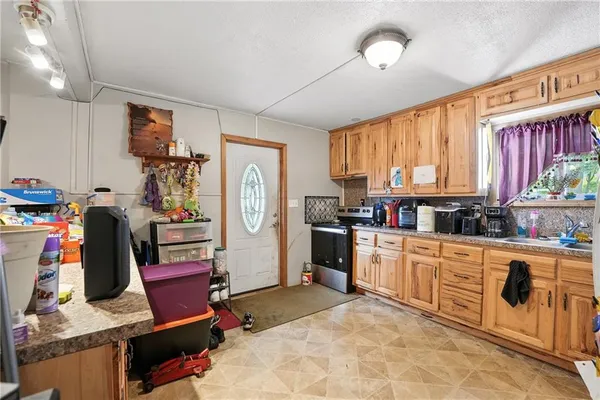 a kitchen with stainless steel appliances kitchen island granite countertop a refrigerator and microwave