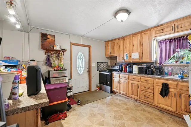 a kitchen with stainless steel appliances kitchen island granite countertop a refrigerator and microwave