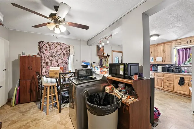 a kitchen with stainless steel appliances kitchen island granite countertop a dining table chairs and a refrigerator