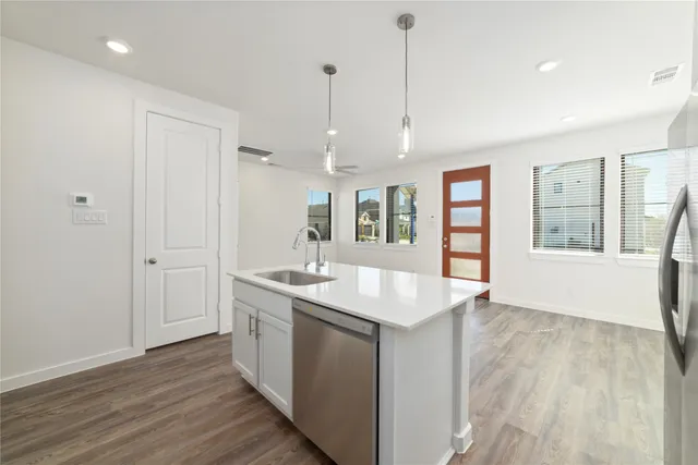 a kitchen with granite countertop white cabinets and stainless steel appliances