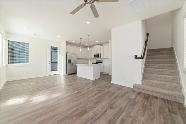 a view of kitchen view wooden floors appliances and cabinets