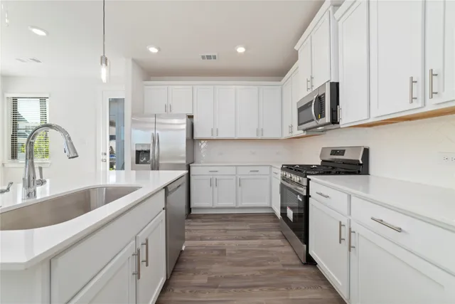 a kitchen with kitchen island a sink stainless steel appliances and cabinets
