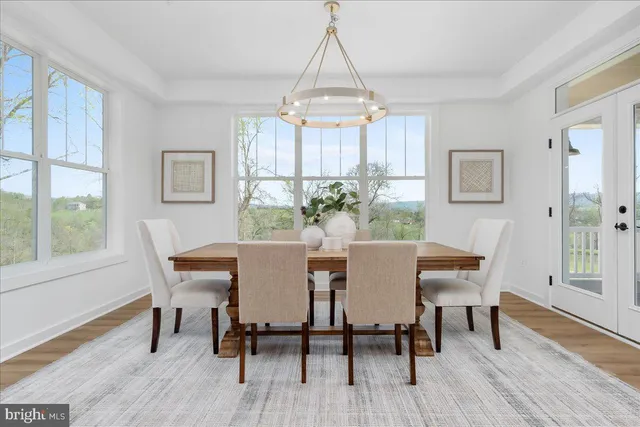 a dining room with furniture a chandelier and wooden floor