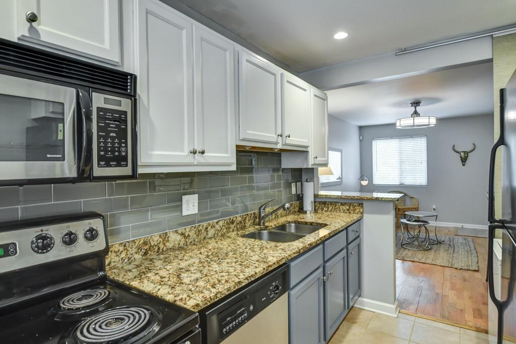 210 Sampson Street Northeast, Unit 5 Atlanta, GA 30312 - Photo 11 of 33 a kitchen with stainless steel appliances granite countertop a sink stove and cabinets