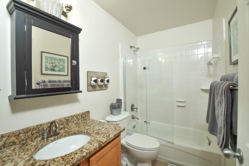 210 Sampson Street Northeast, Unit 5 Atlanta, GA 30312 - Photo 13 of 33 a bathroom with a granite countertop toilet a sink and bathtub