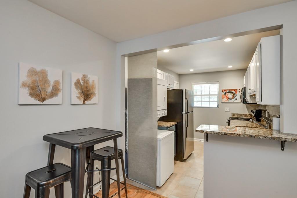 210 Sampson Street Northeast, Unit 5 Atlanta, GA 30312 - Photo 8 of 33 a kitchen with stainless steel appliances kitchen island granite countertop a refrigerator and cabinets