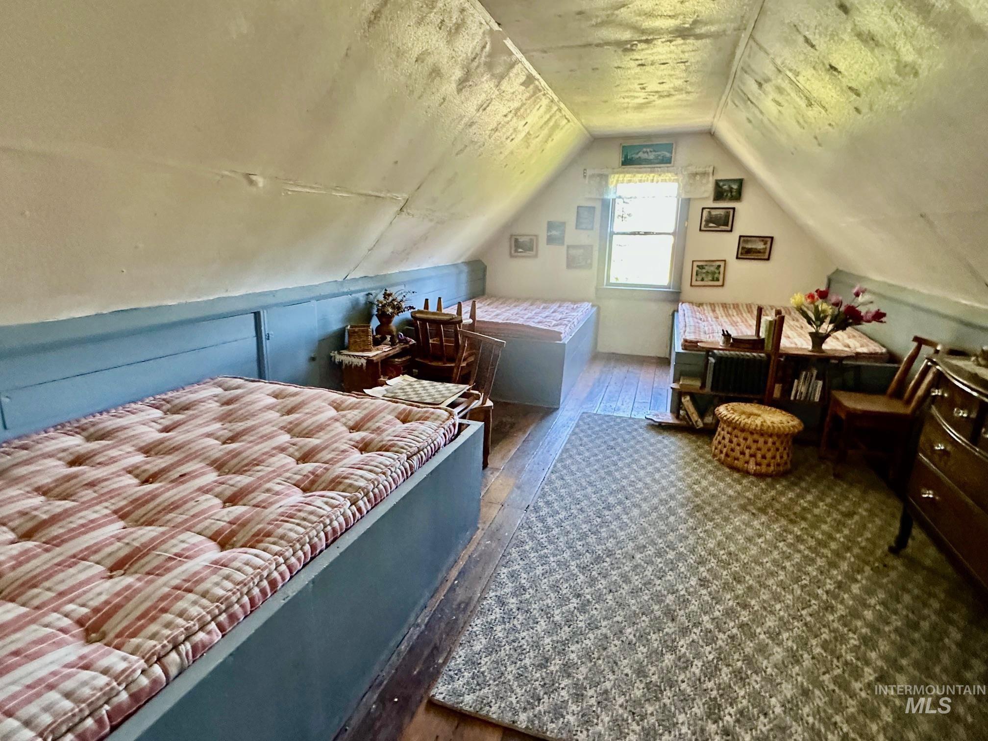 509 Deadline Road, Unit 2 Twin Falls, ID 83301 - Photo 19 of 28 Attic space featuring sloped ceilings, a window, wood-finish flooring, and built-in bed frames with integrated storage