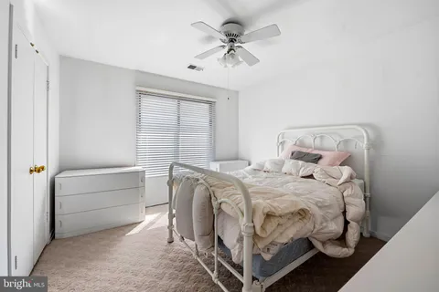 a bedroom with a bed and a ceiling fan