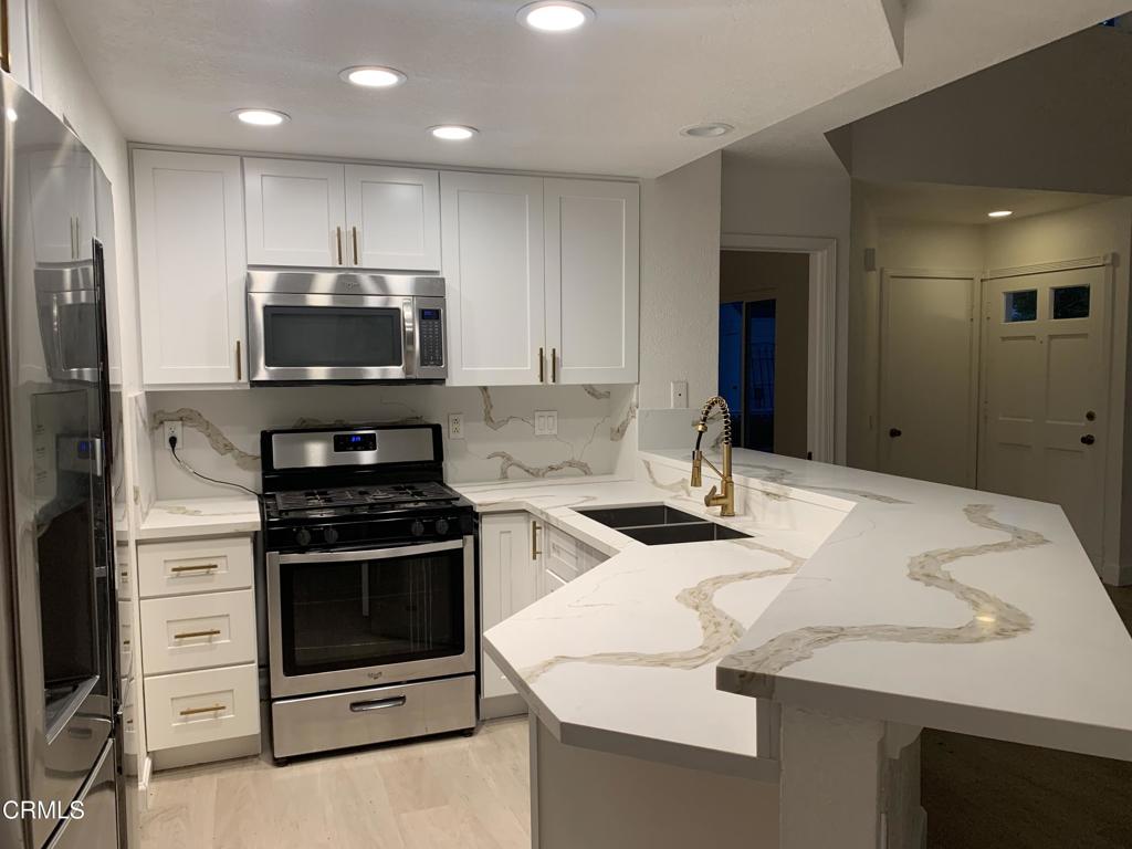 639 Springbrook North, Unit 48 Irvine, CA 92614 - Photo 4 of 12 a kitchen with a sink a stove and refrigerator