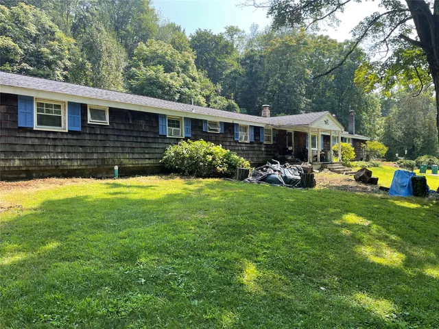 a view of a house with a big yard and sitting area
