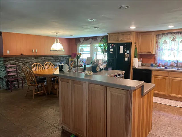 a kitchen with kitchen island granite countertop a sink appliances cabinets and a counter top space