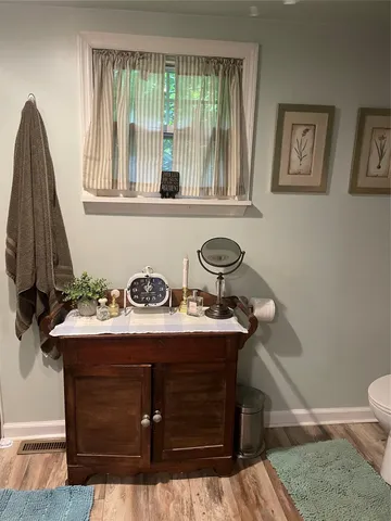 a bathroom with a sink a toilet and a window