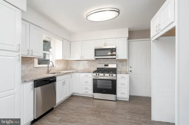 a kitchen with stainless steel appliances granite countertop a stove and a sink