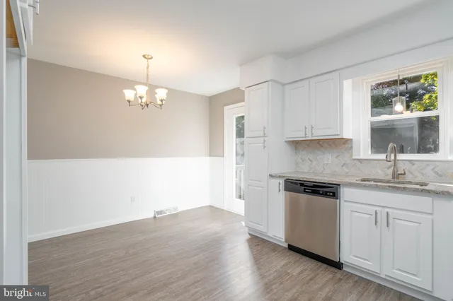 a kitchen with cabinets wooden floor and stainless steel appliances