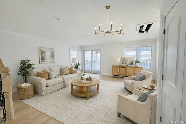 a living room with furniture and a chandelier