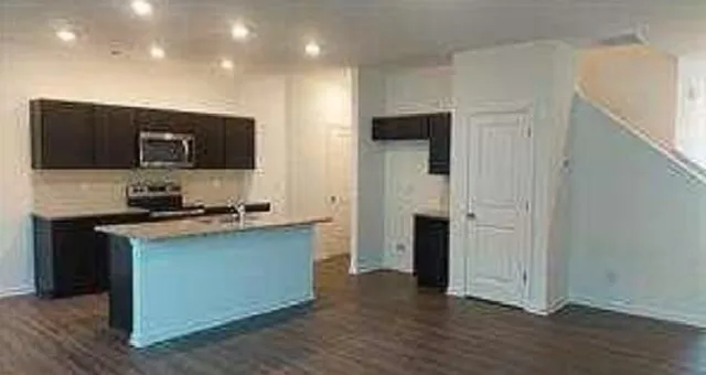 a kitchen with stainless steel appliances granite countertop a stove a sink and a refrigerator