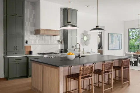 a kitchen with stainless steel appliances a sink stove and table chair