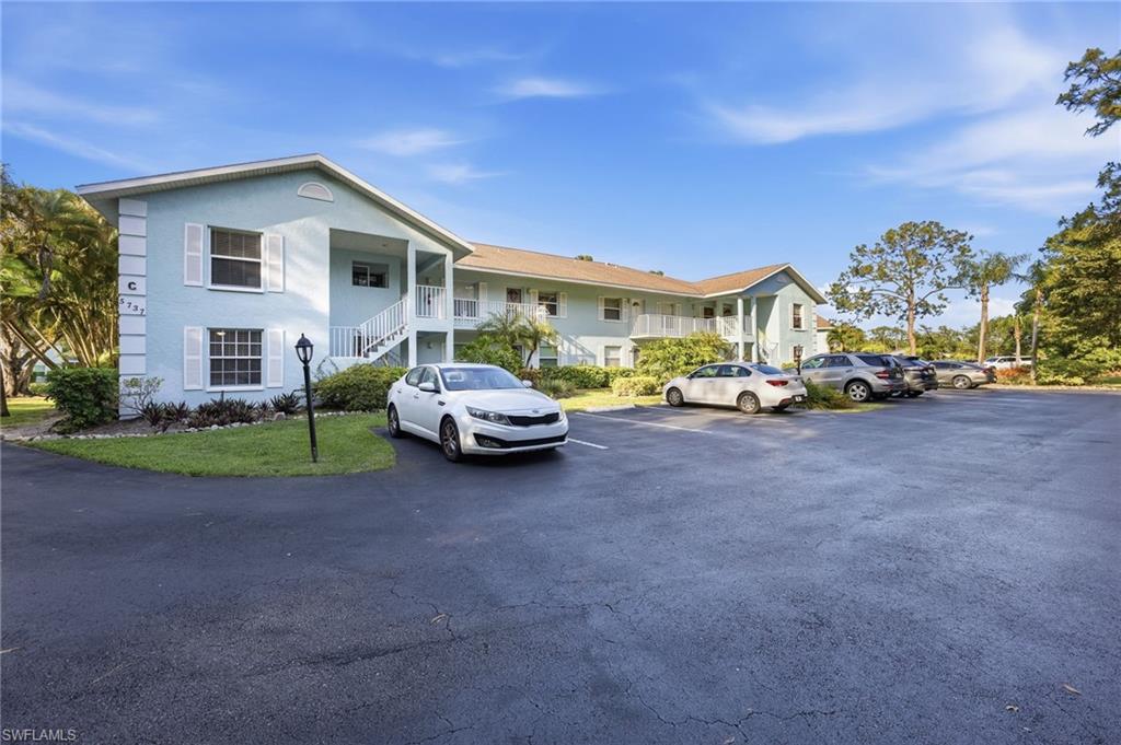 5737 Whitaker Road, Unit C101 Naples, FL 34112 - Photo 21 of 28 a view of a house with a cars park in front of it
