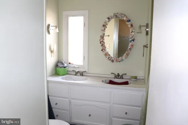 a bathroom with a sink vanity and mirror