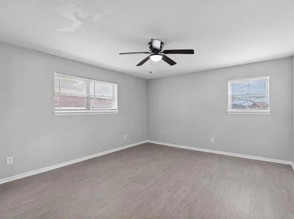 a view of a big room with wooden floor and windows
