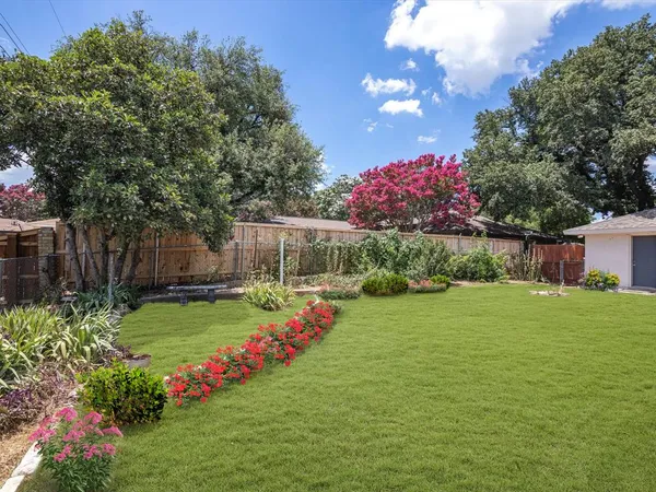 a view of a garden with flowers and a fountain