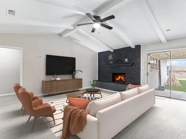 a living room with furniture a flat screen tv and a fireplace
