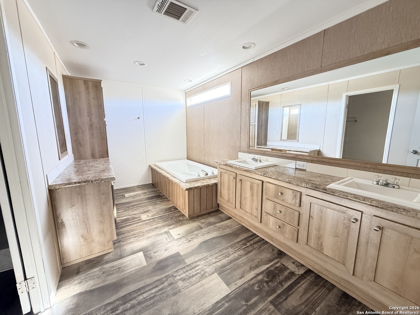 1009 County Road 773 Devine, TX 78016 - Photo 11 of 15 a spacious bathroom with a double vanity sink and mirror