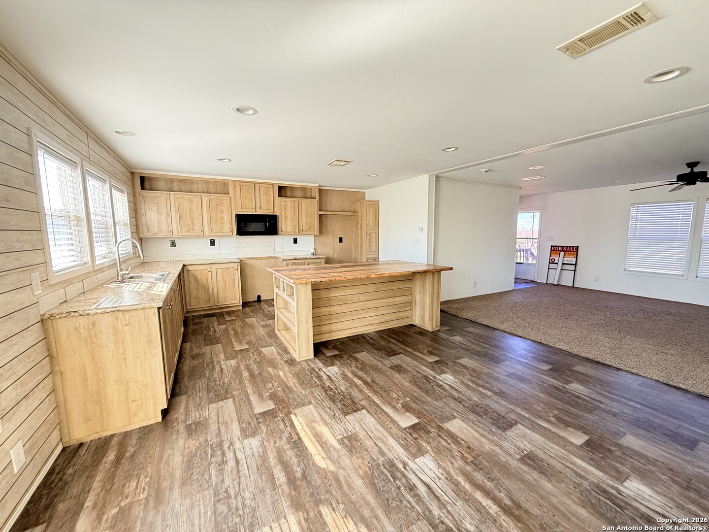 1009 County Road 773 Devine, TX 78016 - Photo 4 of 15 a large white kitchen with cabinets appliances and a wooden floor