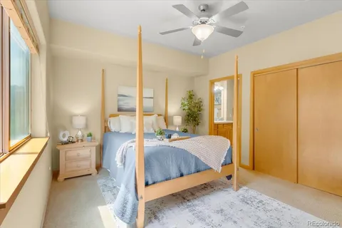 a bedroom with a bed and large windows