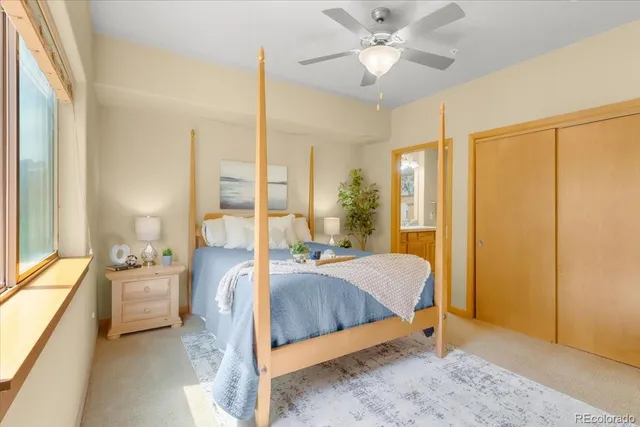 a bedroom with a bed and large windows