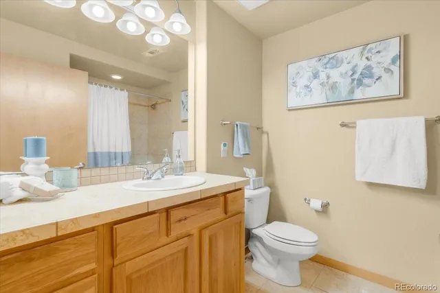 a bathroom with a granite countertop sink mirror vanity and toilet