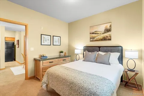 a bedroom with a bed and a painting on the wall