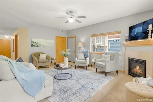 a living room with furniture a fireplace and large windows