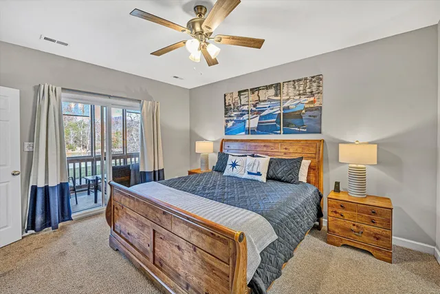 a bedroom with a bed a ceiling fan and a large window